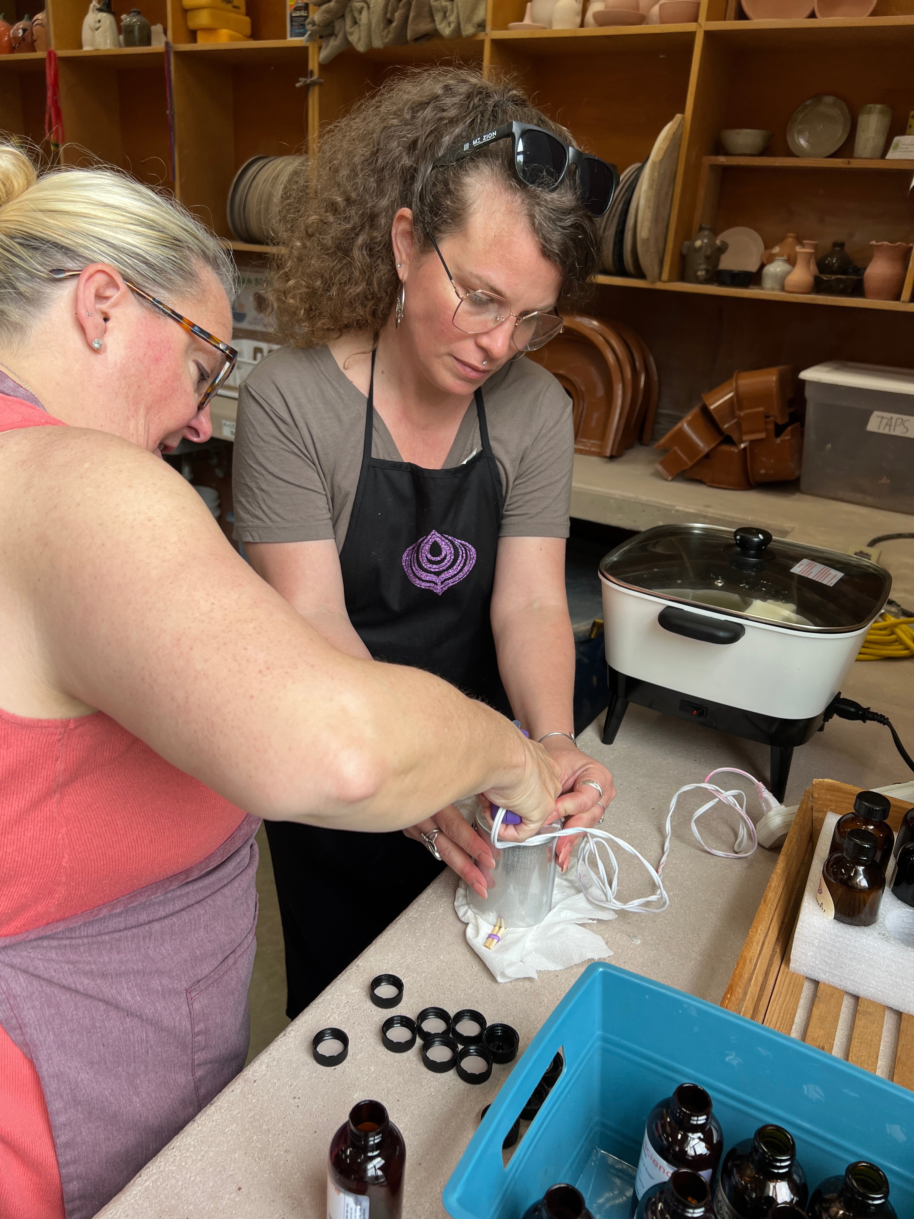 Two people working together in a workshop setting with tools and materials around.