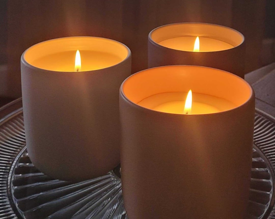 three candles burning on glass plate