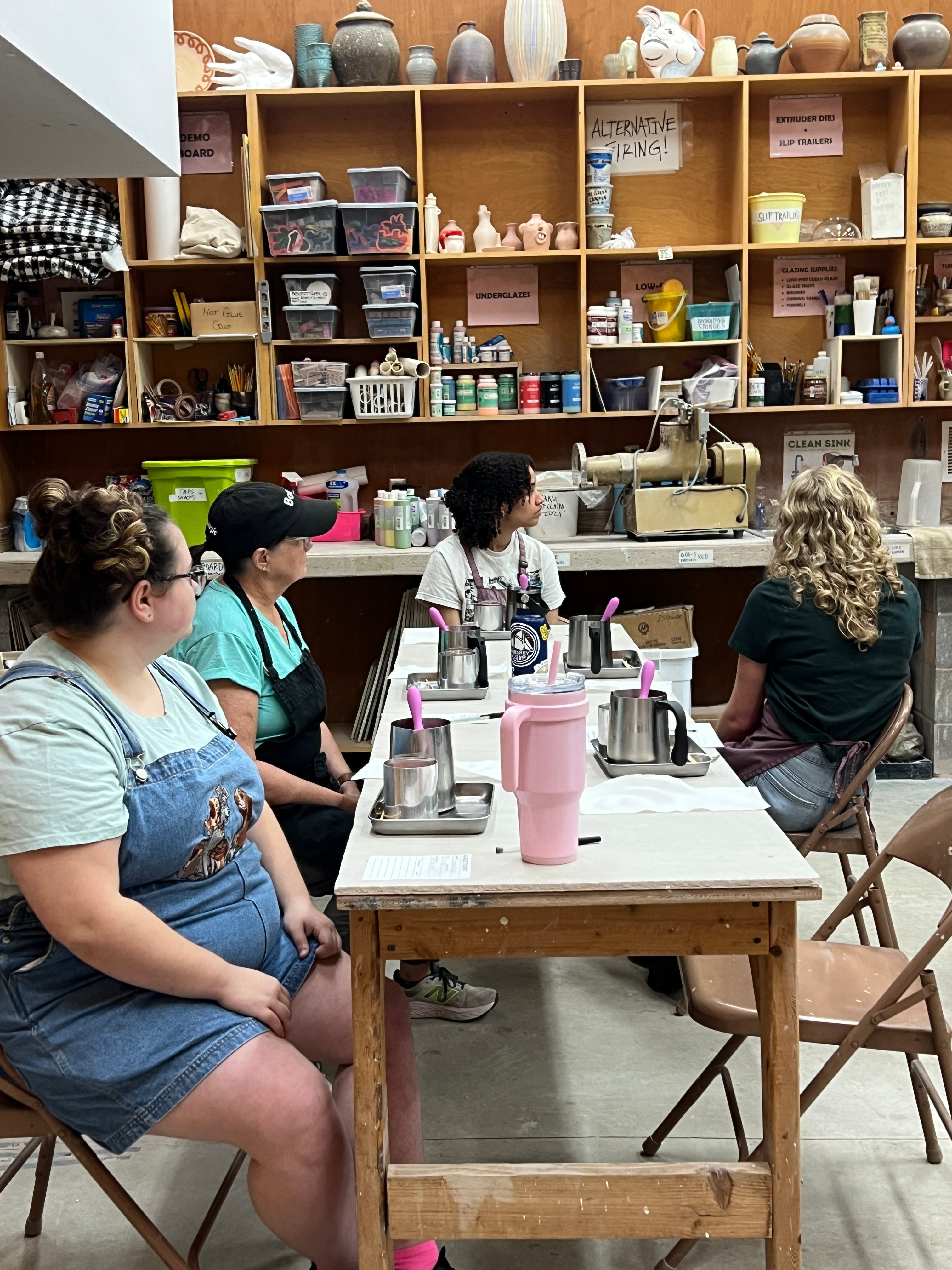 People doing a candle workshop in a store with shelves filled with products.